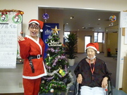 クリスマスツリーをバックに良い笑顔で写っています。